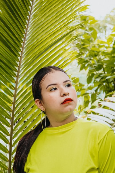 站在棕榈叶旁的女人
